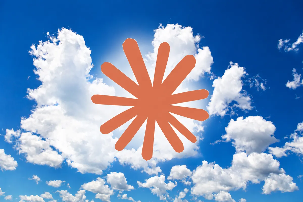 Claudes orange, stjerneformede logo foran en blå himmel med hvide skyer.